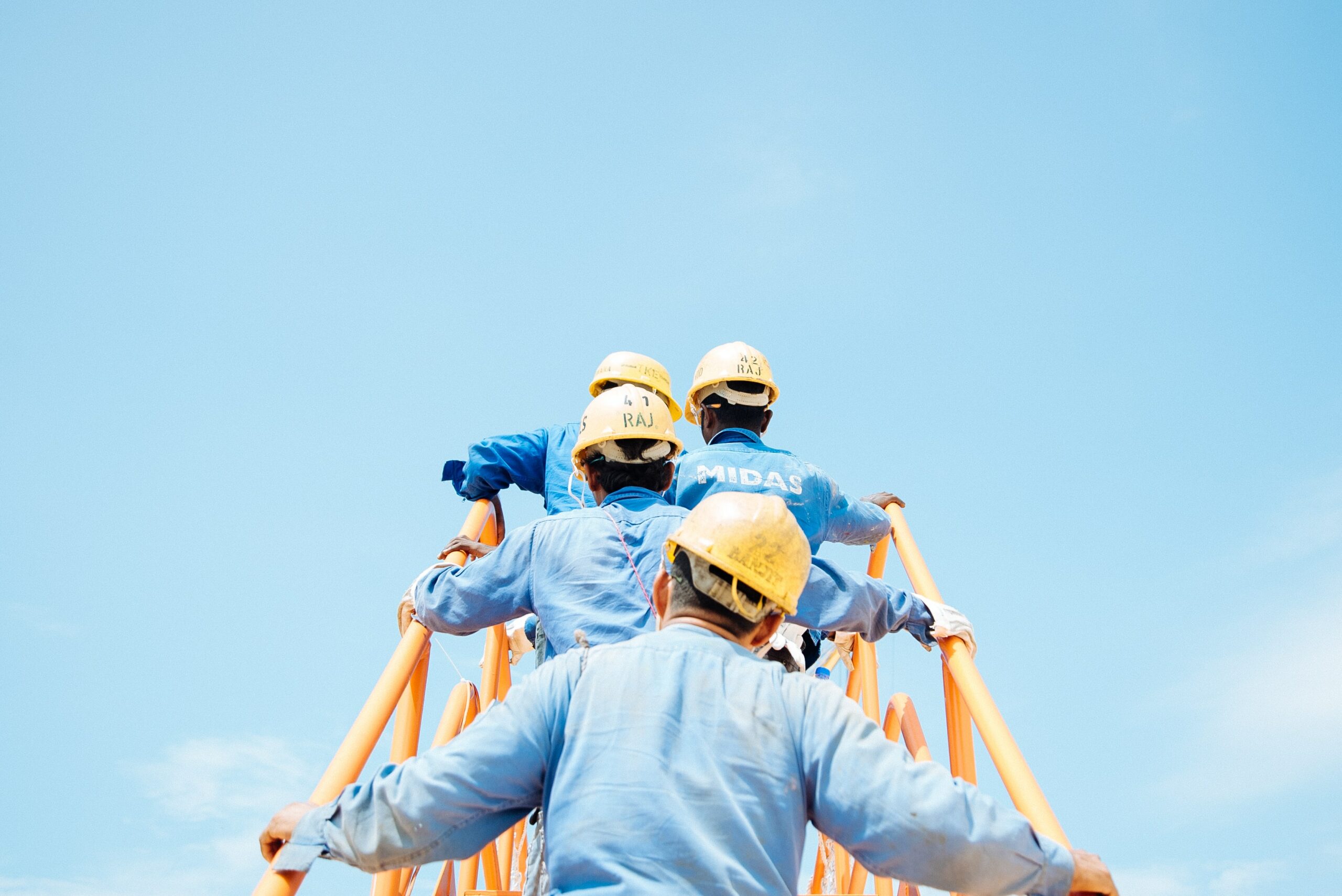 employees hard hats solar construction ladder sky