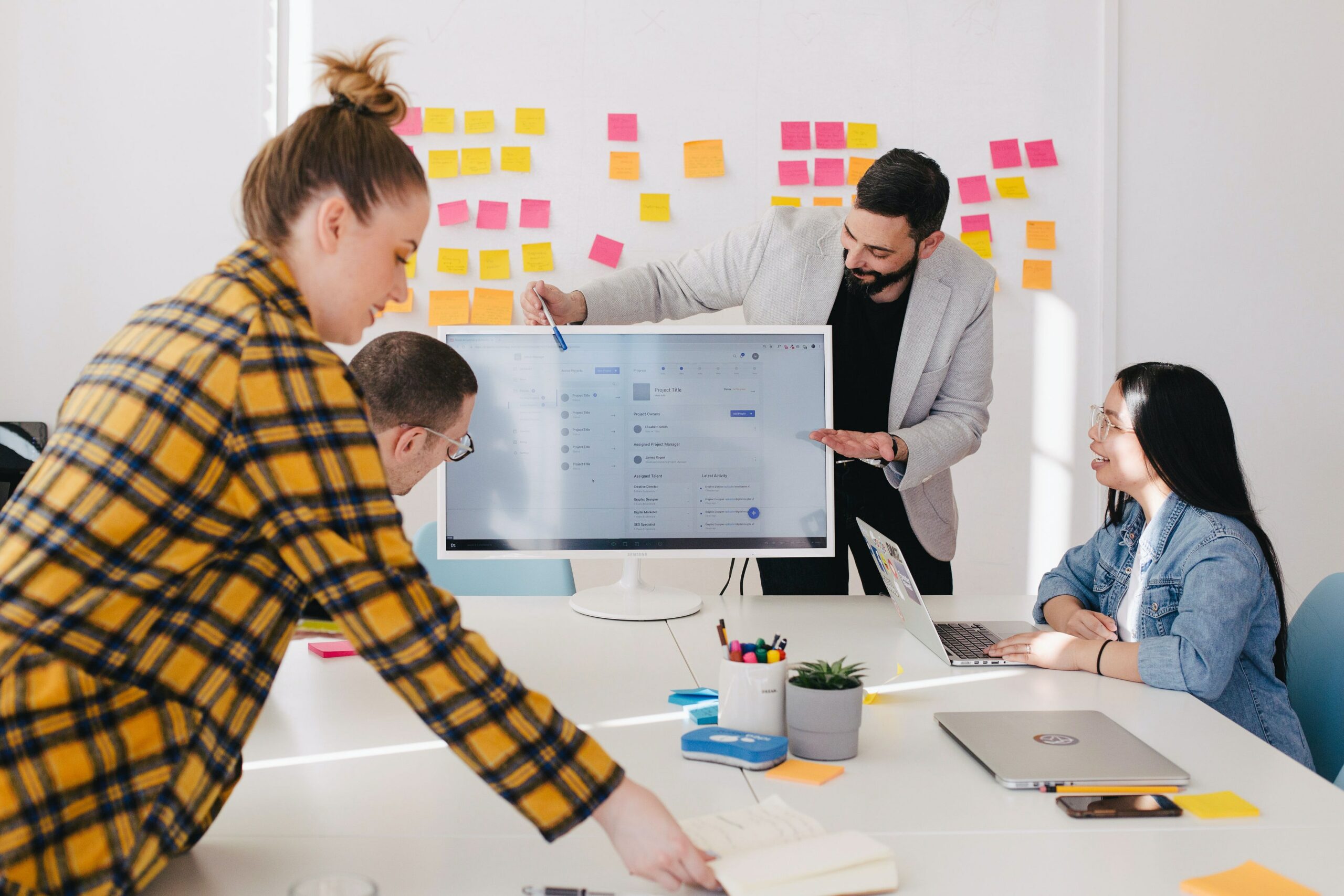 group of employees office meeting computer brainstorm