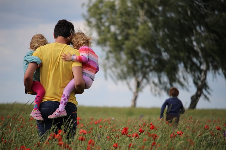 family walking in a grassy field