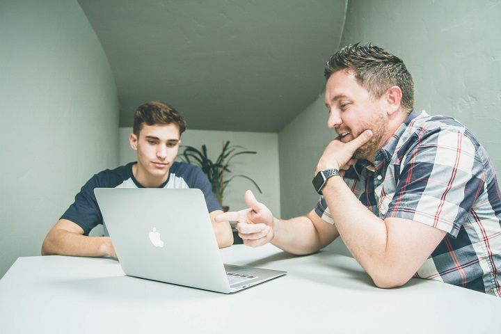Retaining Employees: Helping Your Solar Workers Grow Their Careers 1 two male solar workers discussion laptop office