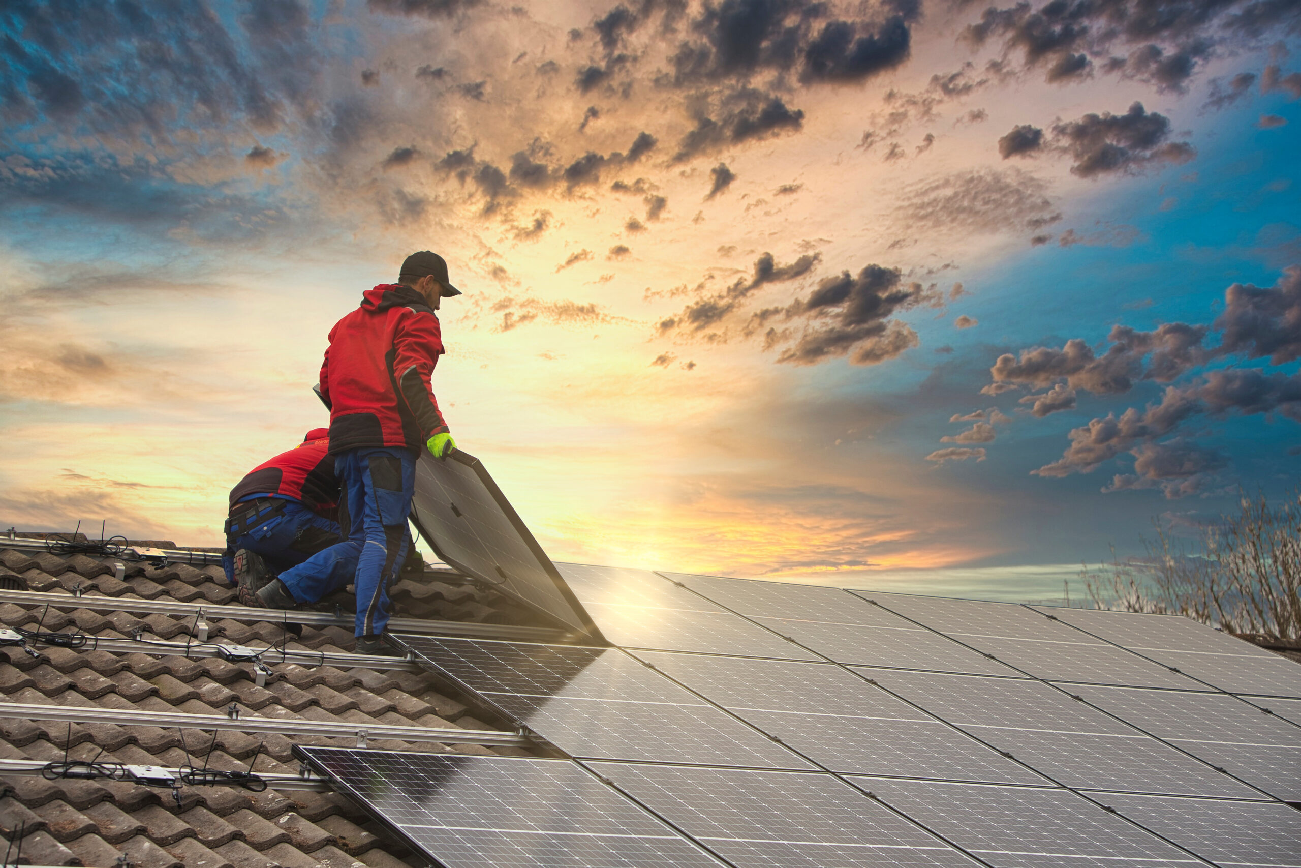 residential solar panel installation two technicians on roof sunset scaled