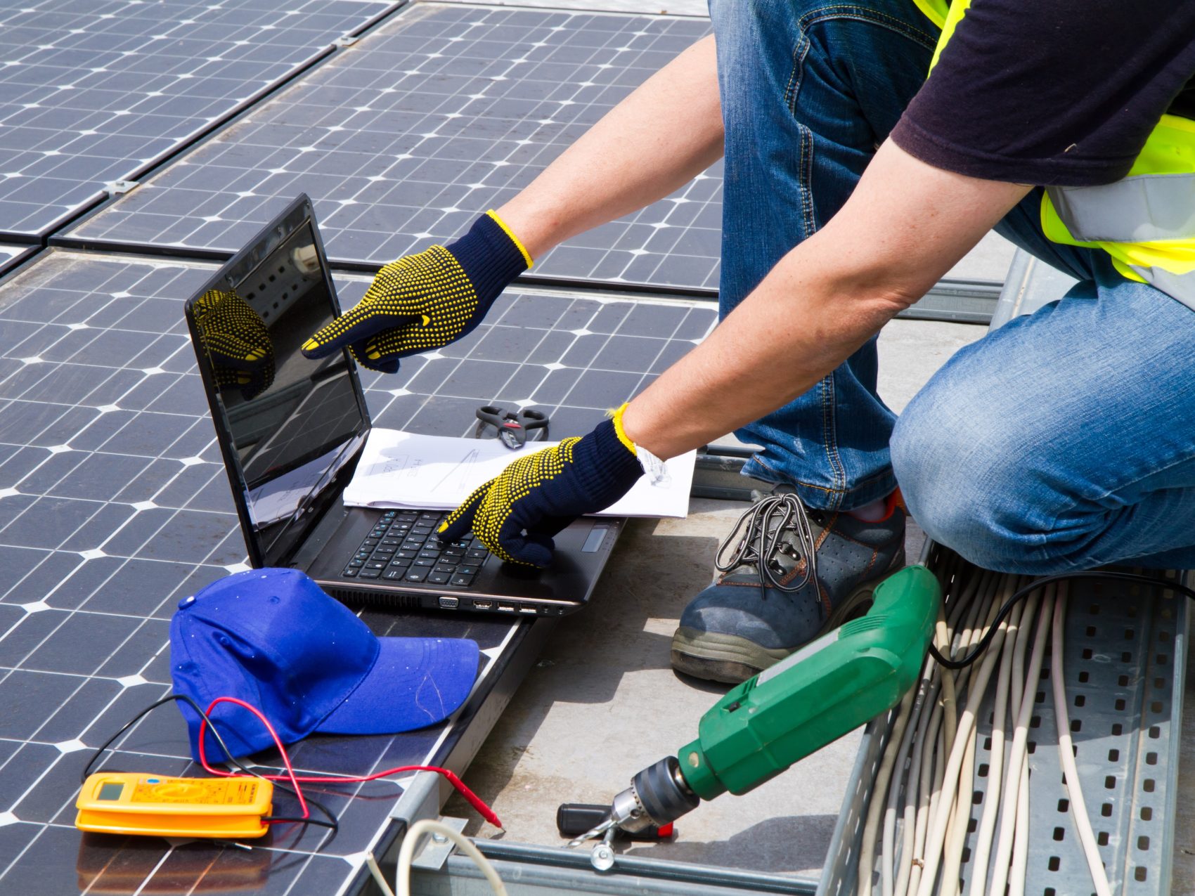 solar operations panel installation computer laptop roof technician using solar software