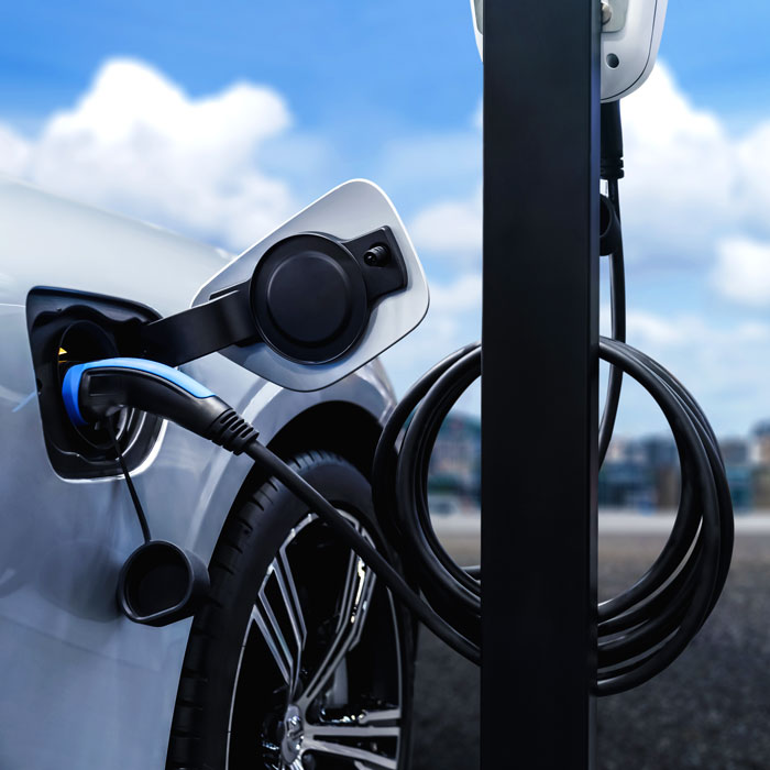 ev charging station plugged into silver car