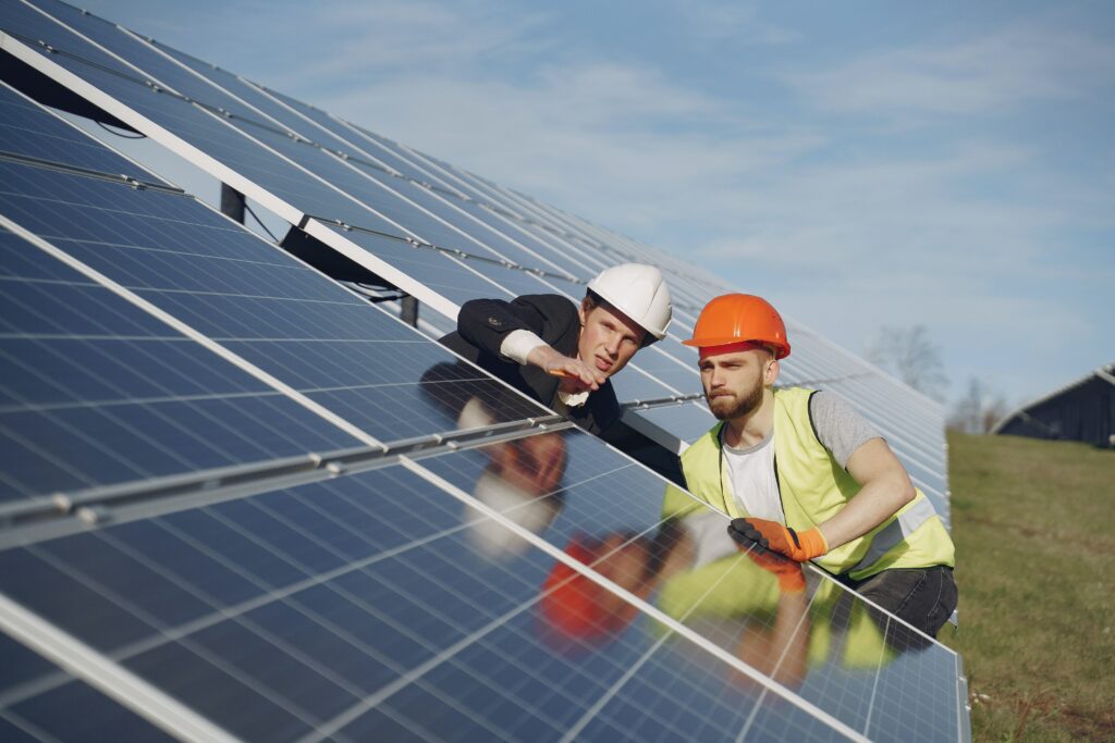 construction workers examining solar panels