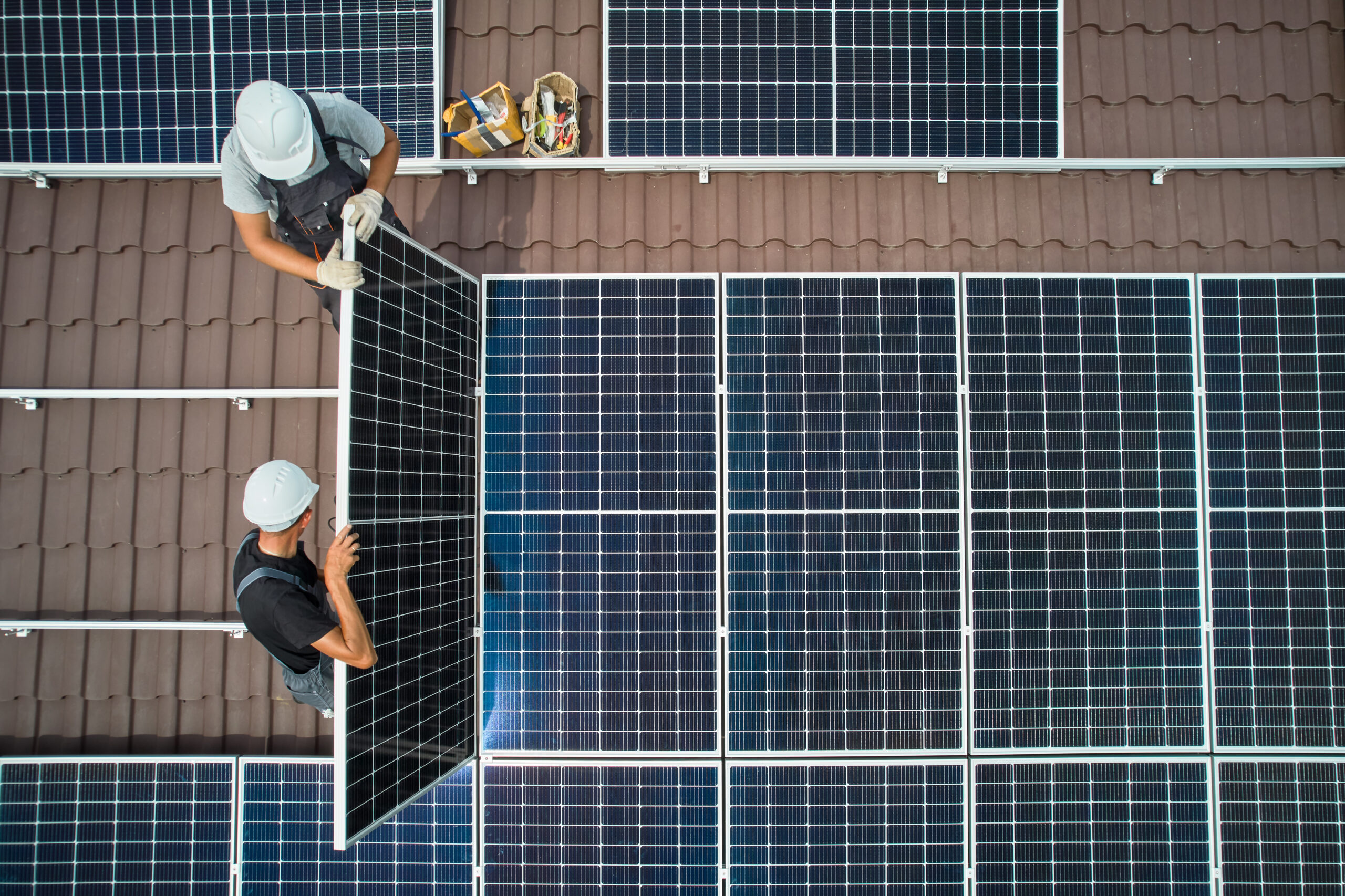 solar technicians mounting photovoltaic pv solar panels on roof of house