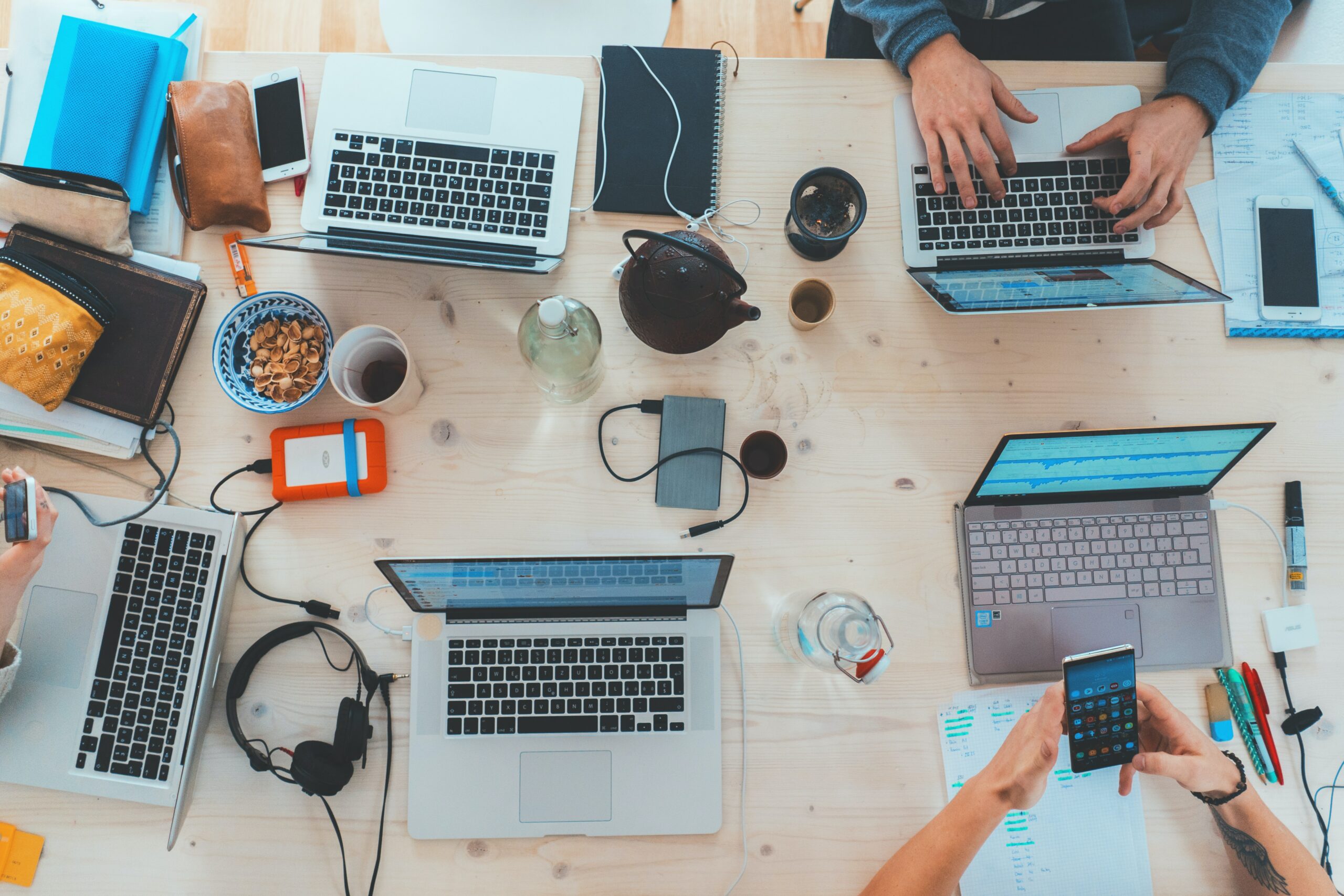 group of people working on laptops phones table