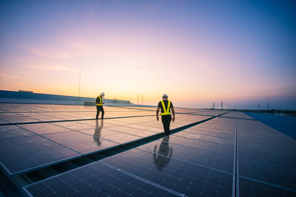 commercial solar installation with workers at sunset