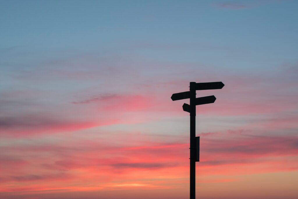 four way directional sign at sunset