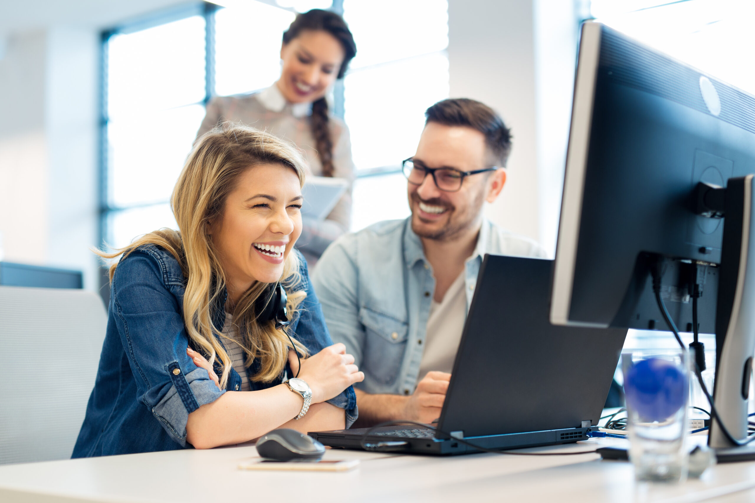 team collaboration laughing working in office computer