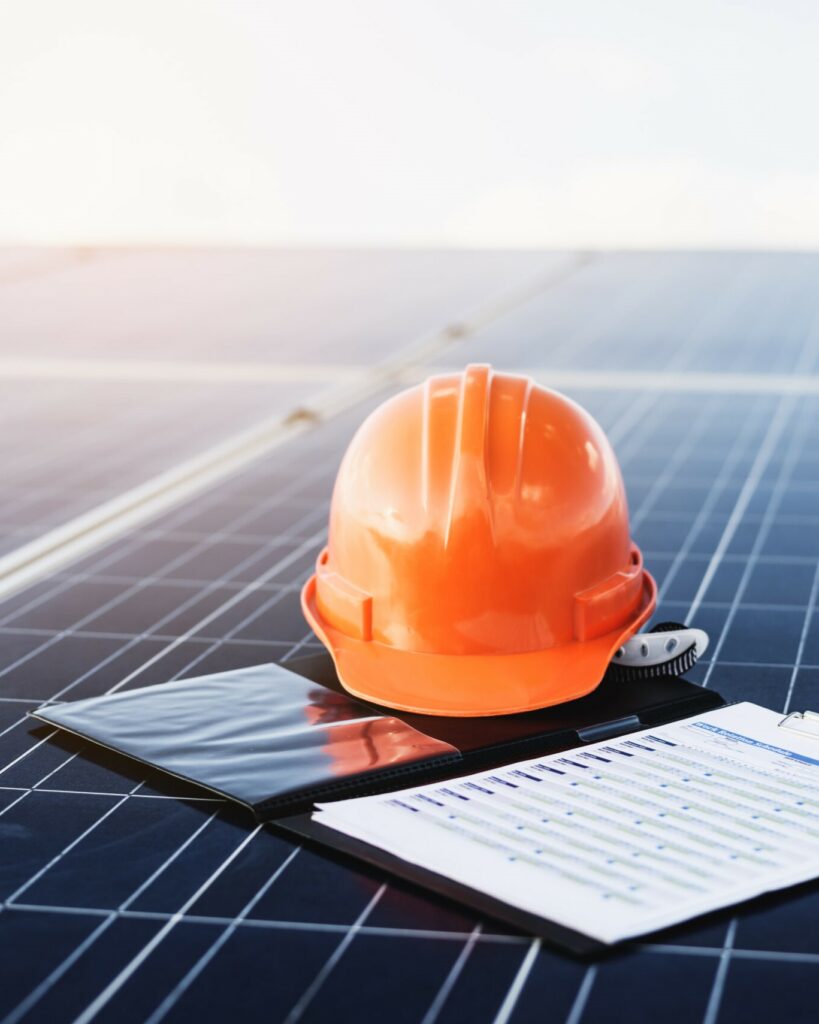 solar panels with hard hat and paperwork cropped